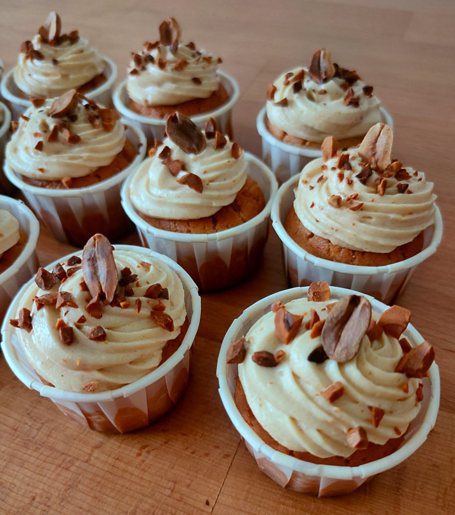 Cupcakes vegan avec glaçage praliné et éclats de fruits secs, parfaits pour les gâteaux de voyage. Disponibles en plusieurs goûts, y compris vanille, chocolat, praliné, cacahuète et pistache.